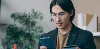 young man with smartphone and credit card - payments via pexels