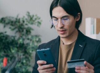 young man with smartphone and credit card - payments via pexels